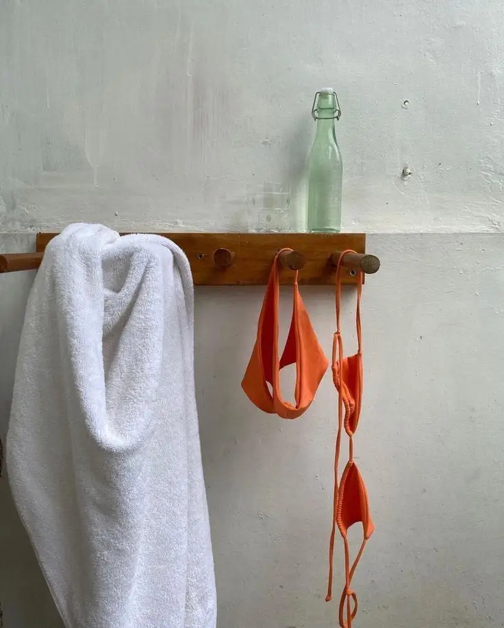 A rack with red and white towels and a bottle of soap.