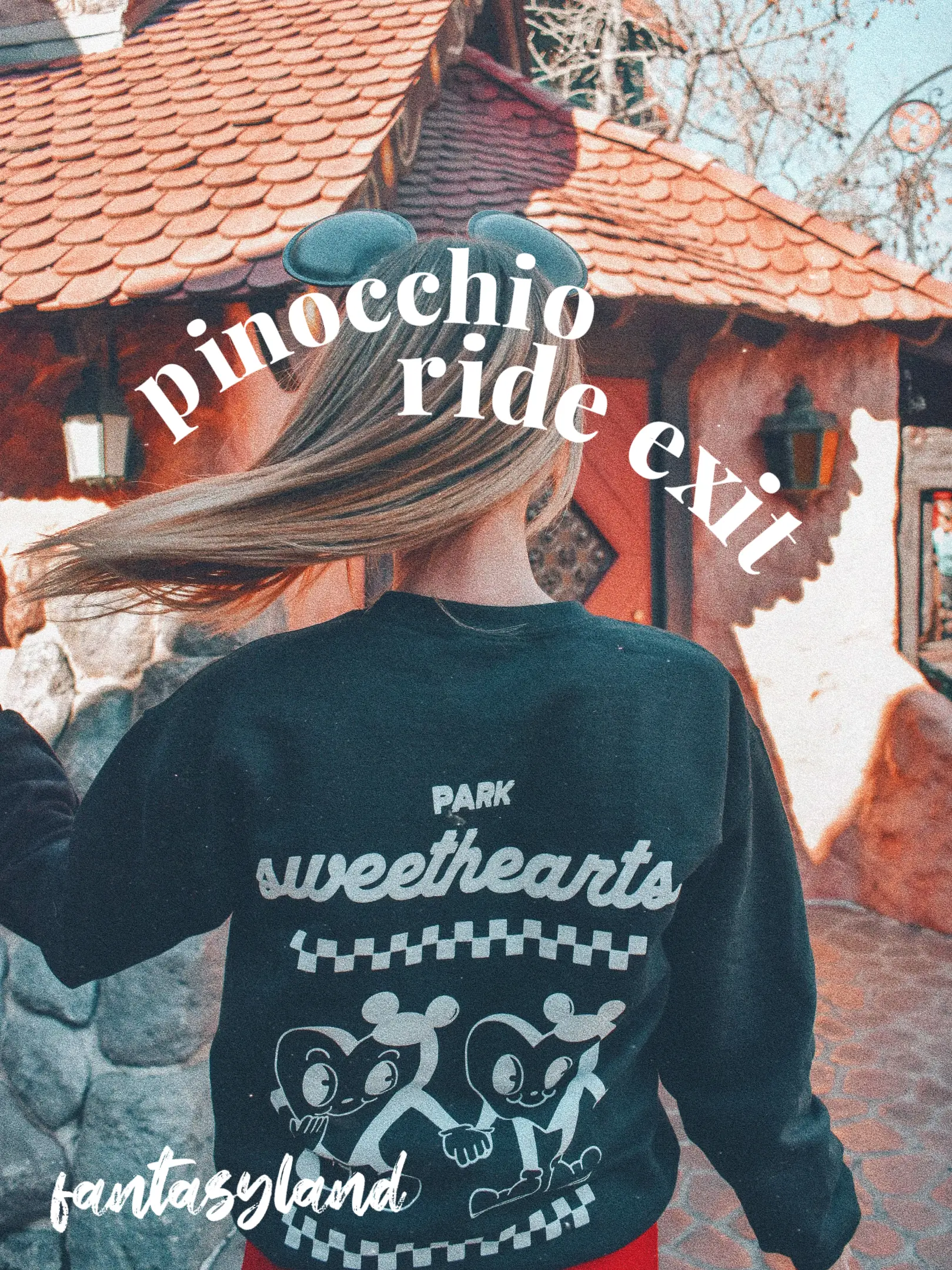  A man wearing a pinocchio ride fantasyland sweatshirt.