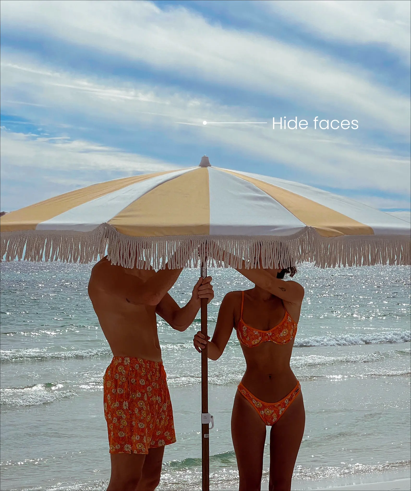  A man and a woman are standing on a beach, holding umbrellas to protect themselves from the sun. The woman is wearing a bikini and the man is wearing shorts.