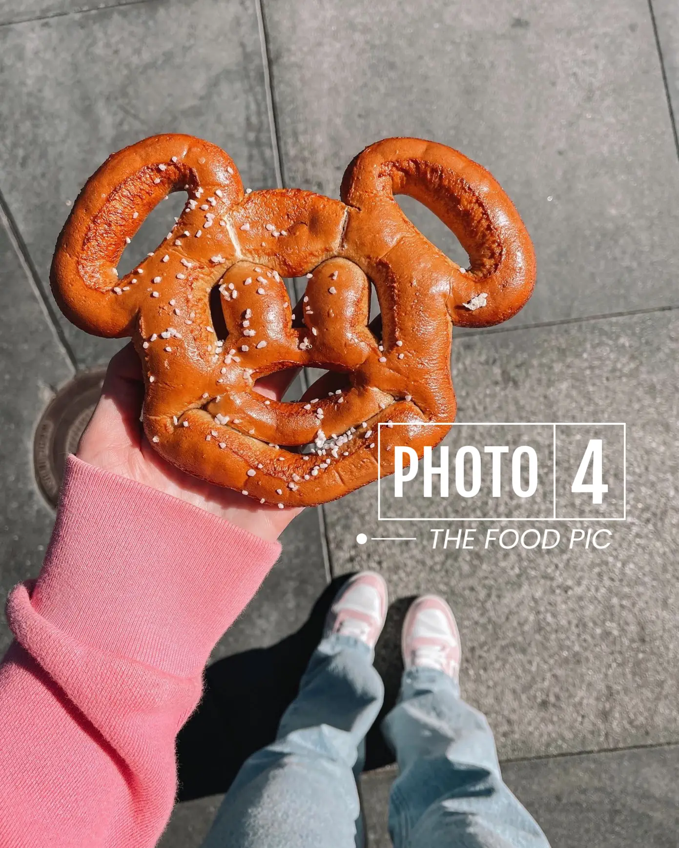  A person is holding a pretzel shaped like Mickey Mouse.