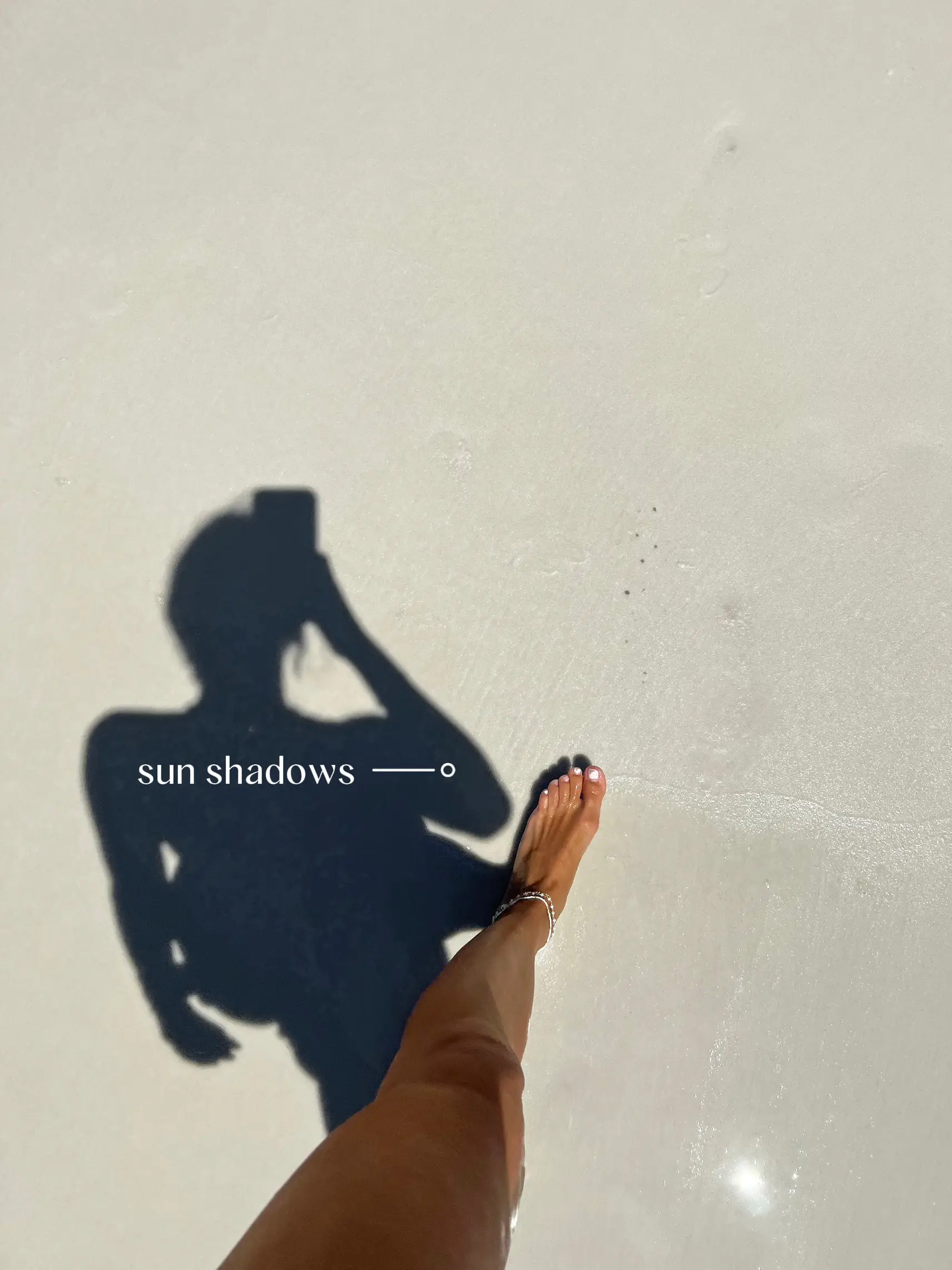  A person's shadow is cast on the sand.