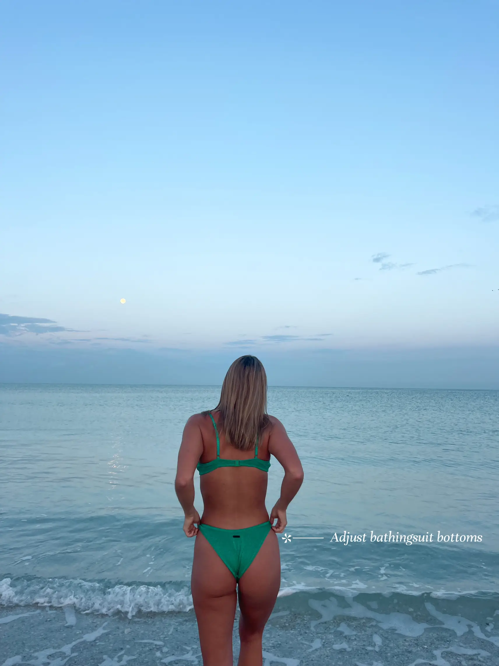  A woman in a bikini is standing on a beach.