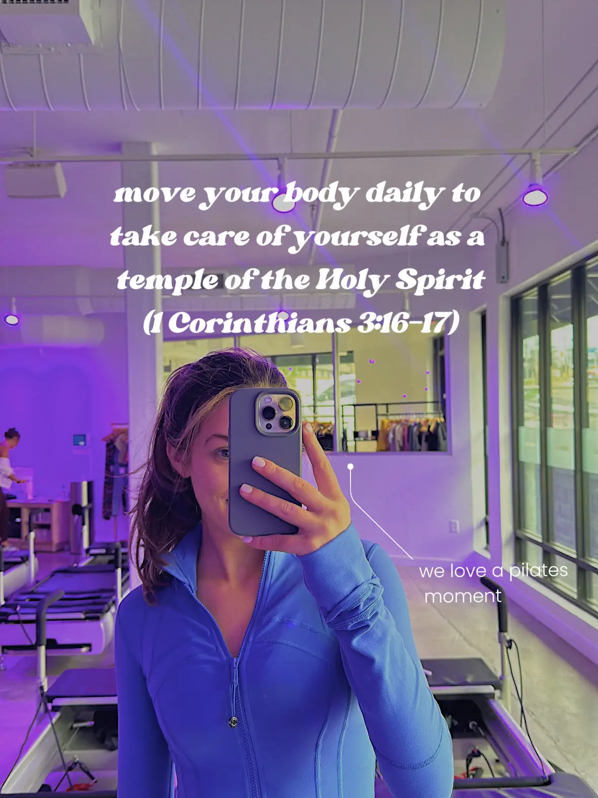  A woman in a blue shirt is taking a selfie in a gym.