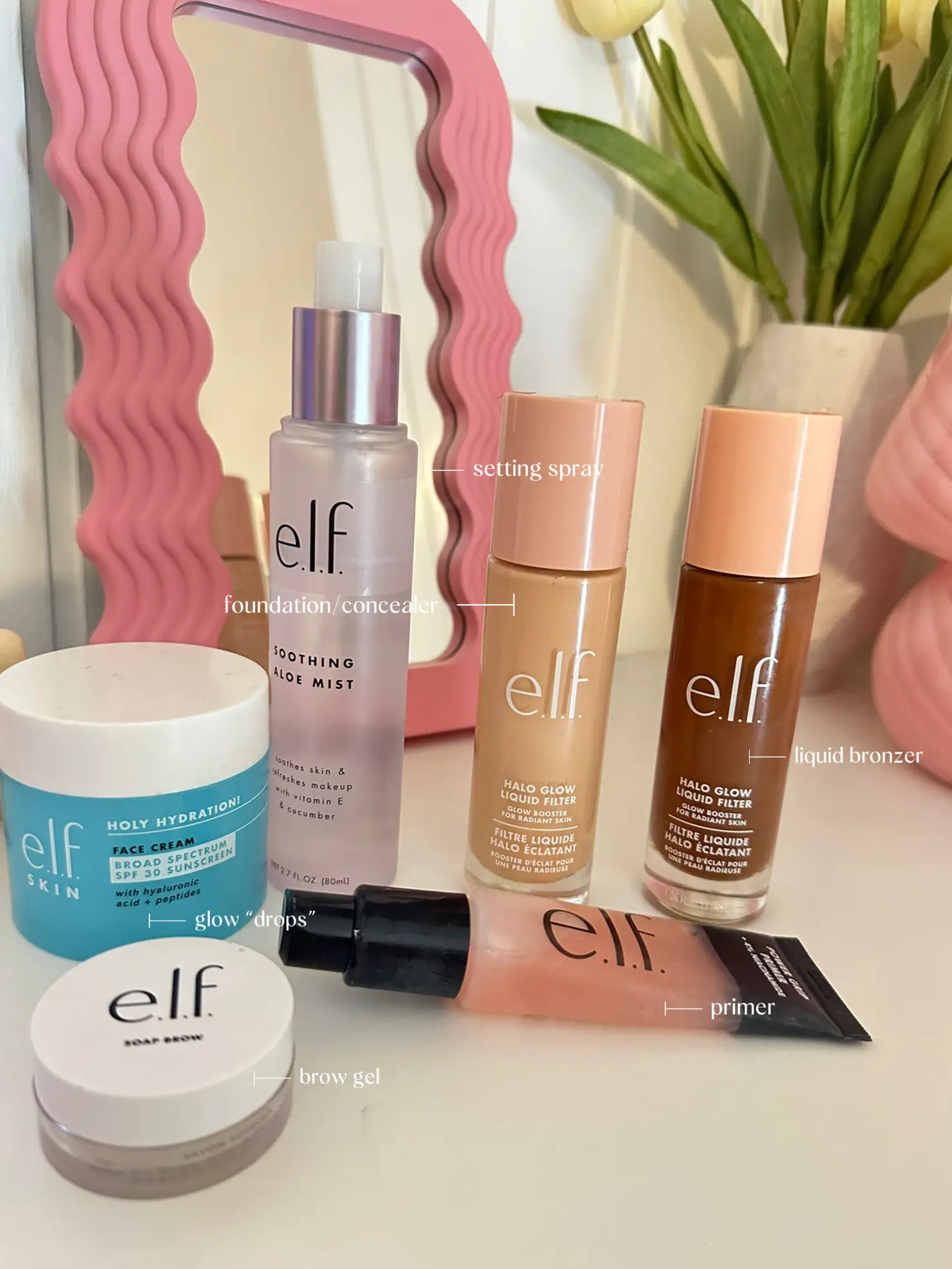  A collection of Elf brand makeup and skincare products, including a tinted moisturizer, a makeup brush, and a bottle of Aloe Vera Mist.