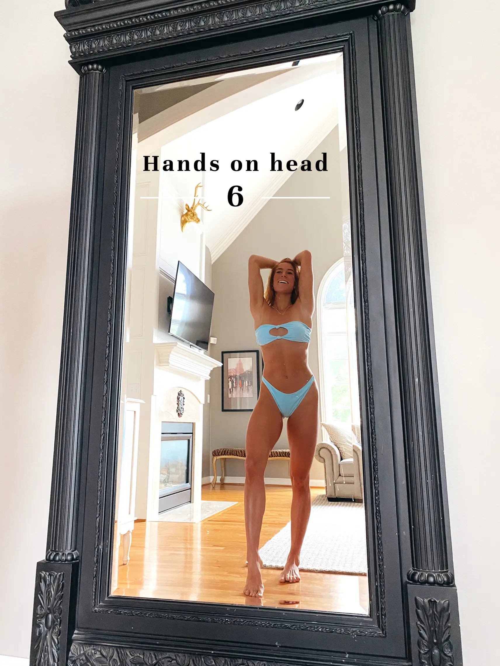  A woman in a bikini is standing in front of a mirror.