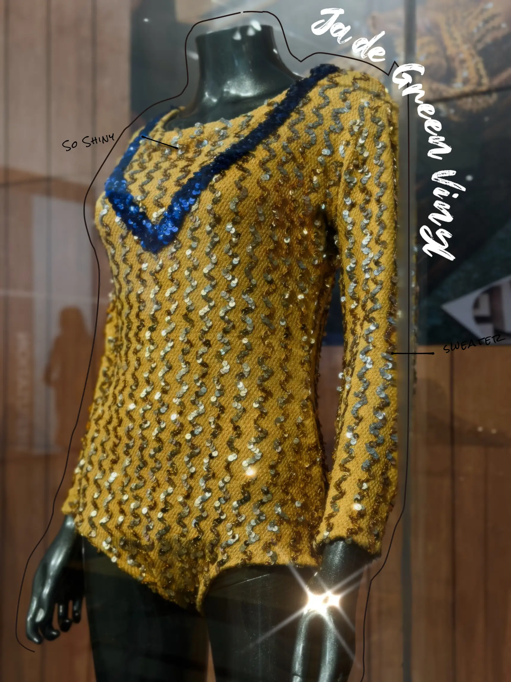  A mannequin wearing a blue sweater with a blue shirt underneath.