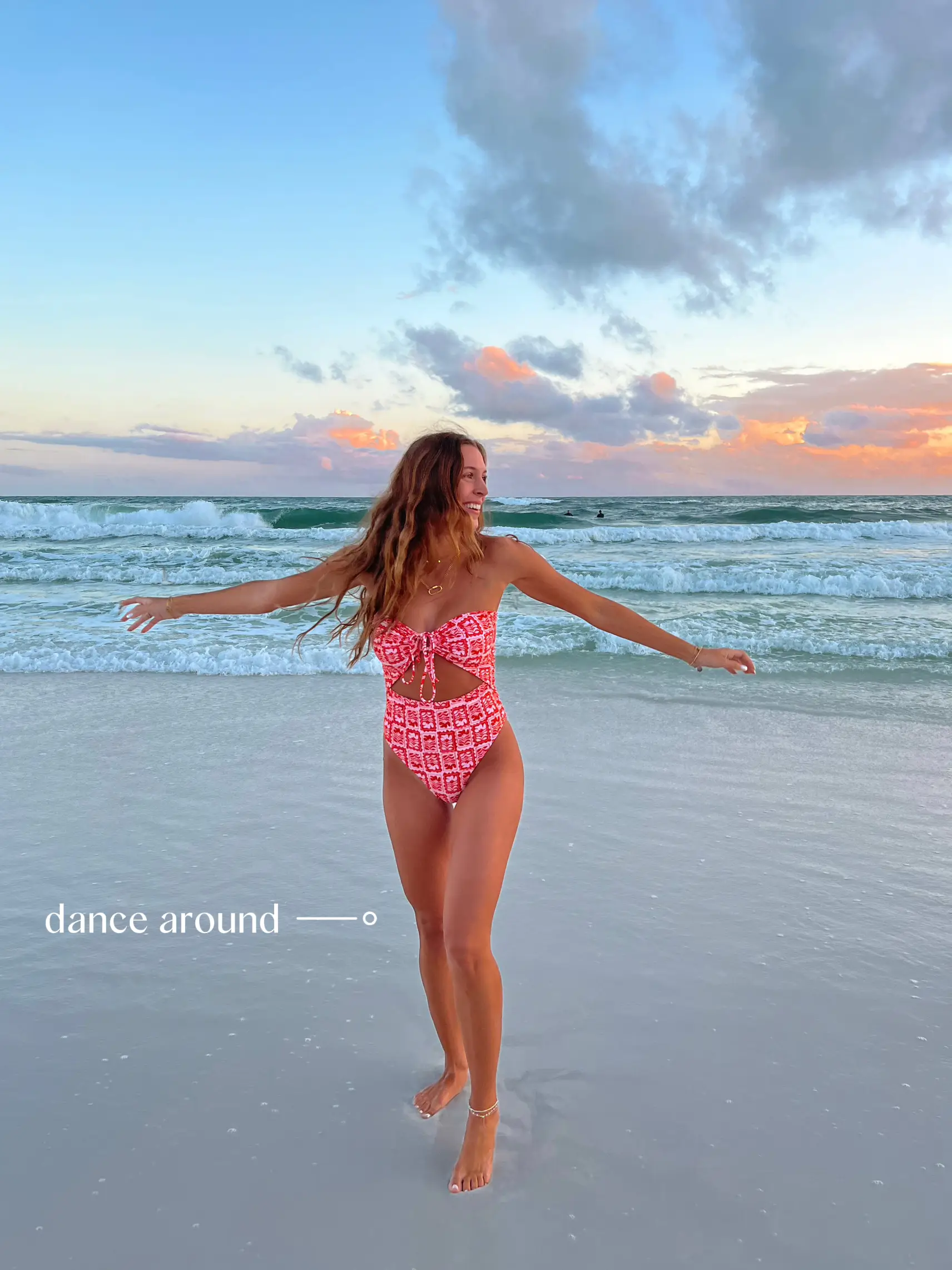  A woman in a pink bikini is standing on a beach.