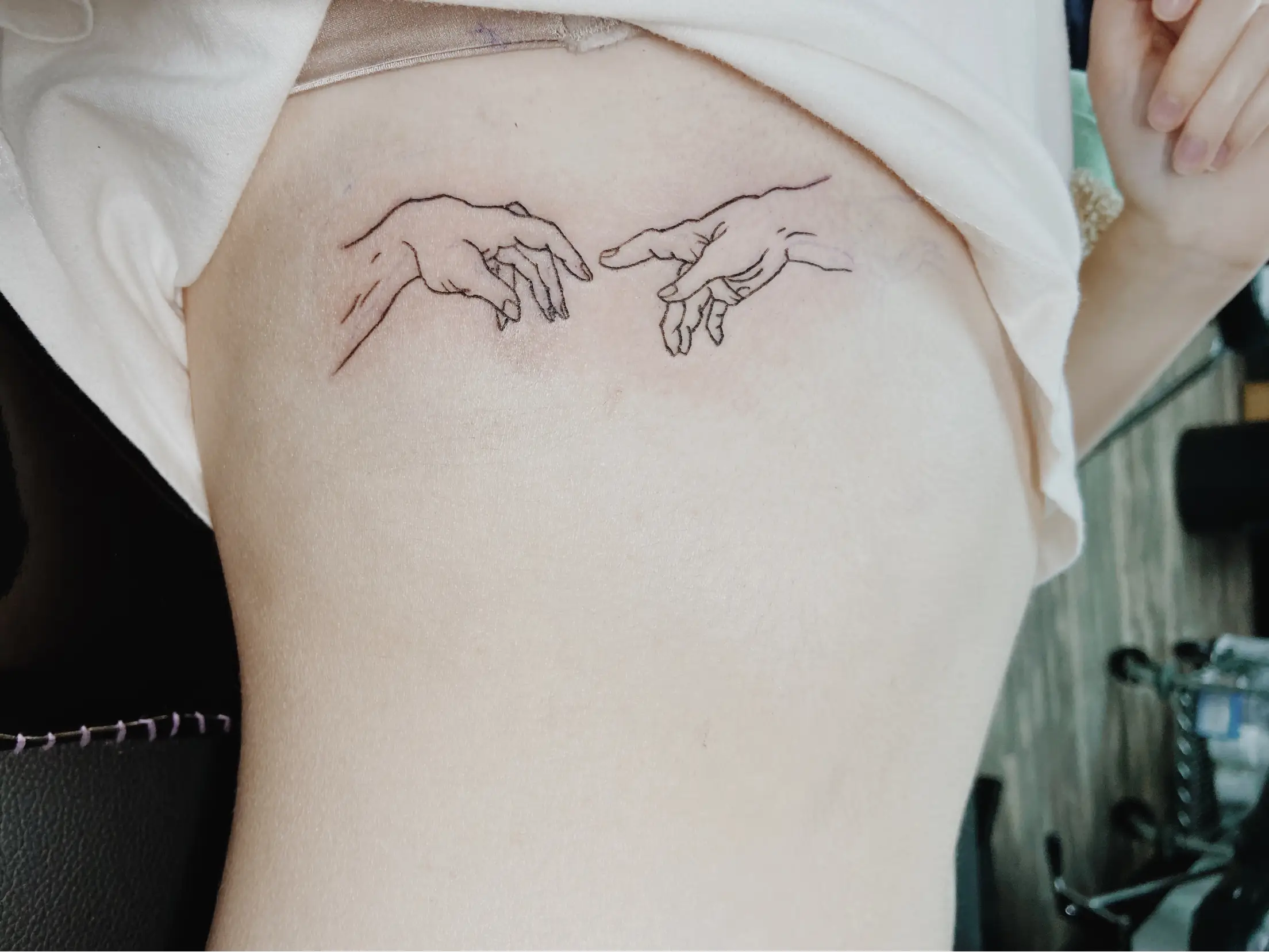 creation of adam hands tattoo