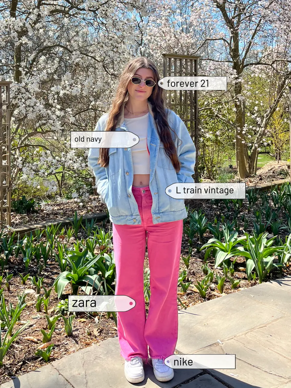  A woman wearing a denim jacket and pink pants is standing in front of a flower bed. The image is labeled with various fashion brands and descriptions.