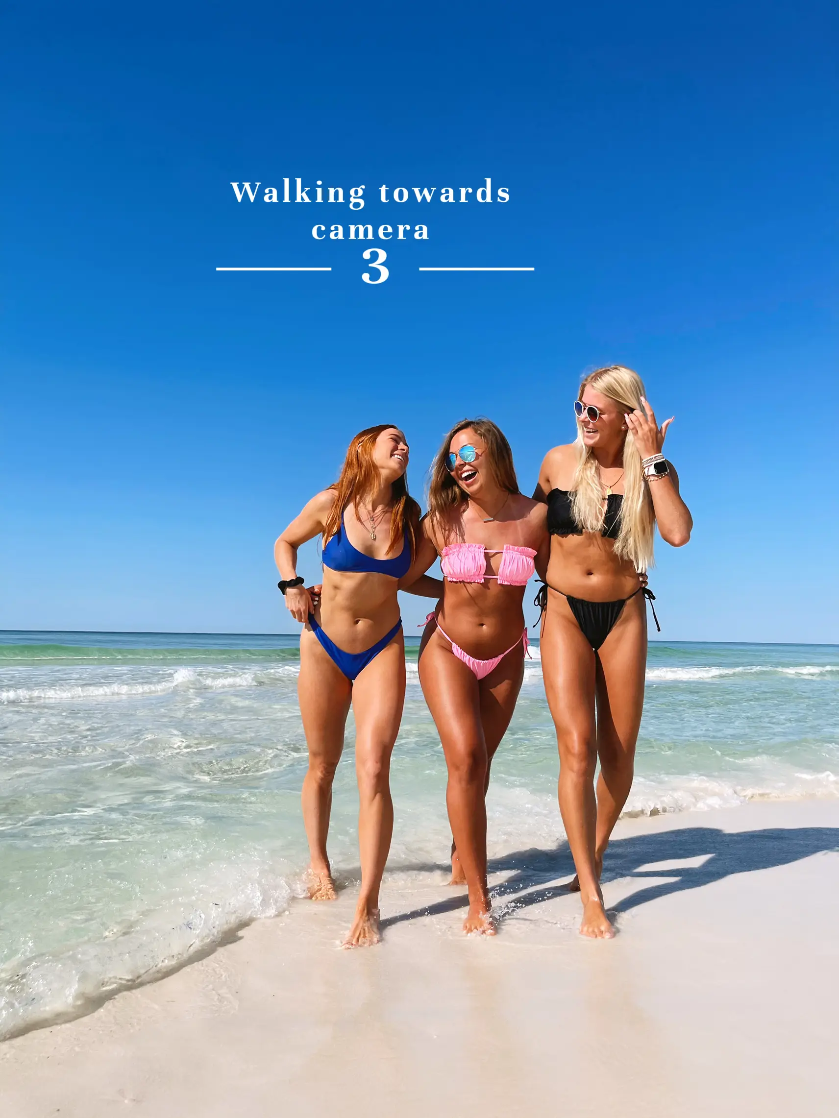  Three women are walking towards the camera on a beach.
