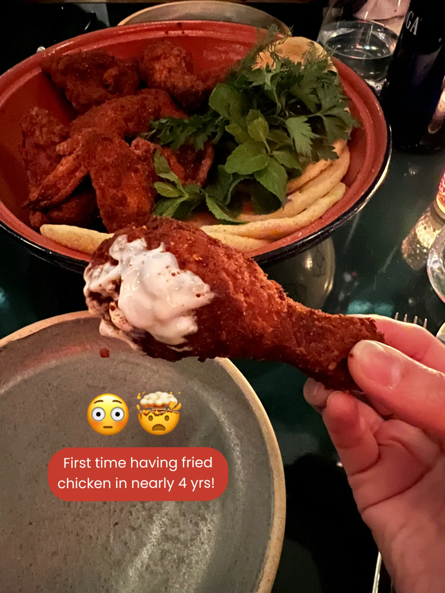  A person is holding a piece of fried chicken in their hand.