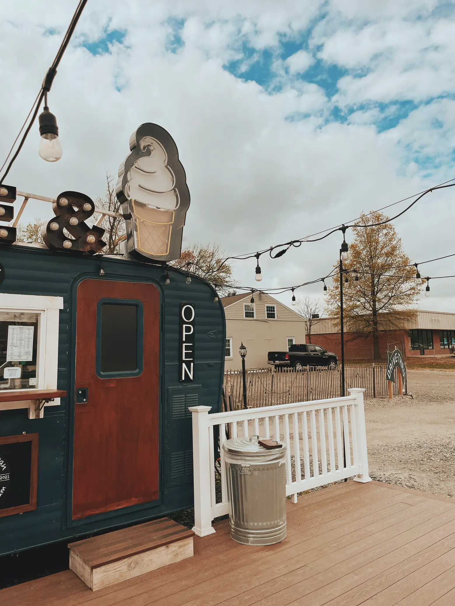  A food truck with a wooden structure and a sign that says "Open".