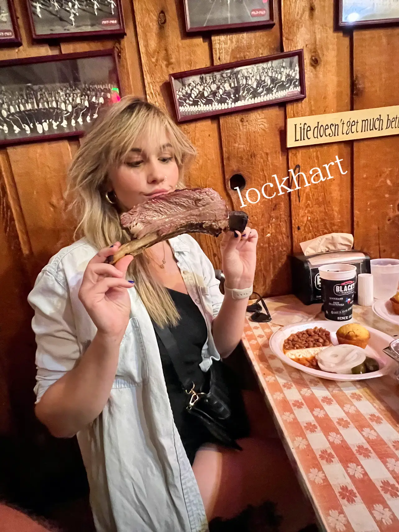  A woman is holding a large piece of meat, which is described as a large piece of meat.