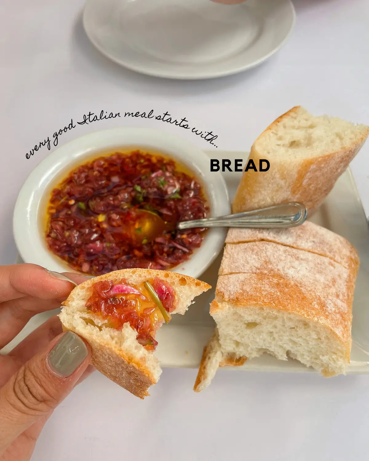  A person is holding a spoon in their hand and is about to eat a slice of bread. The image also contains a bowl of food and a sandwich.