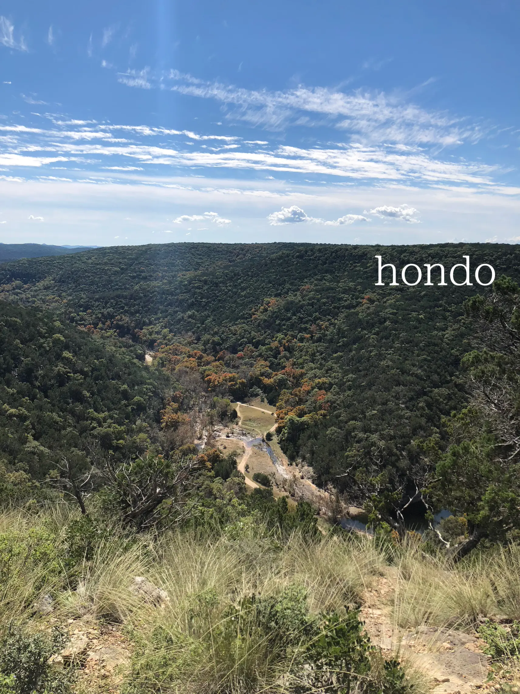  A mountain with a forest on top and the words "hondo 117" written on it.