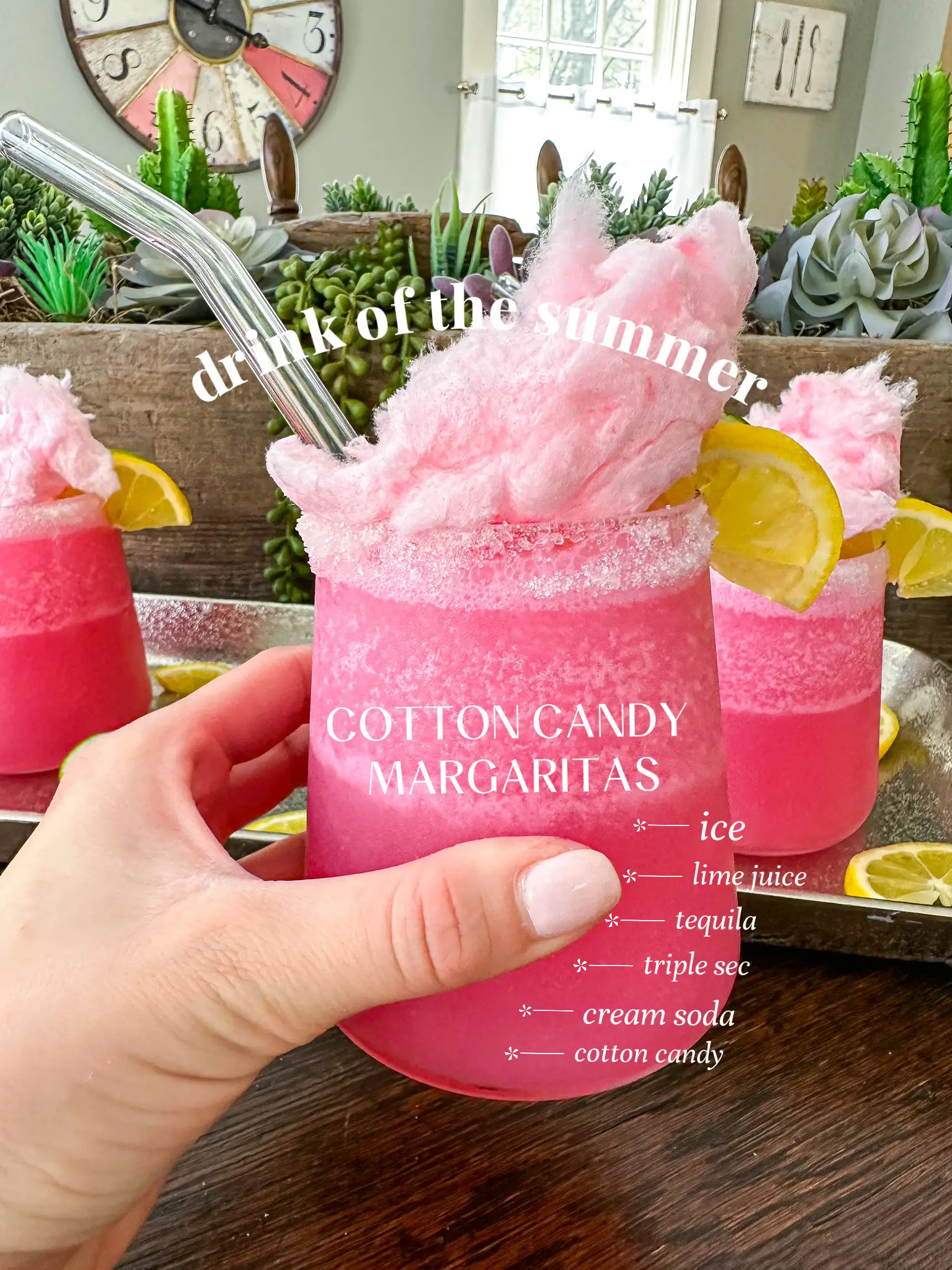  A hand holding a glass of cotton candy margaritas.