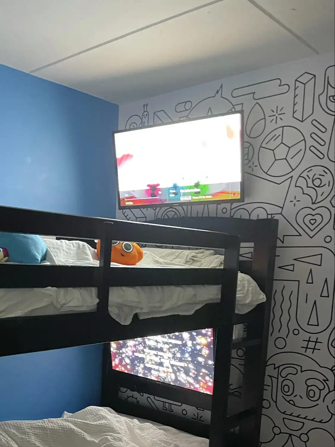  A bedroom with a bed and two TVs.