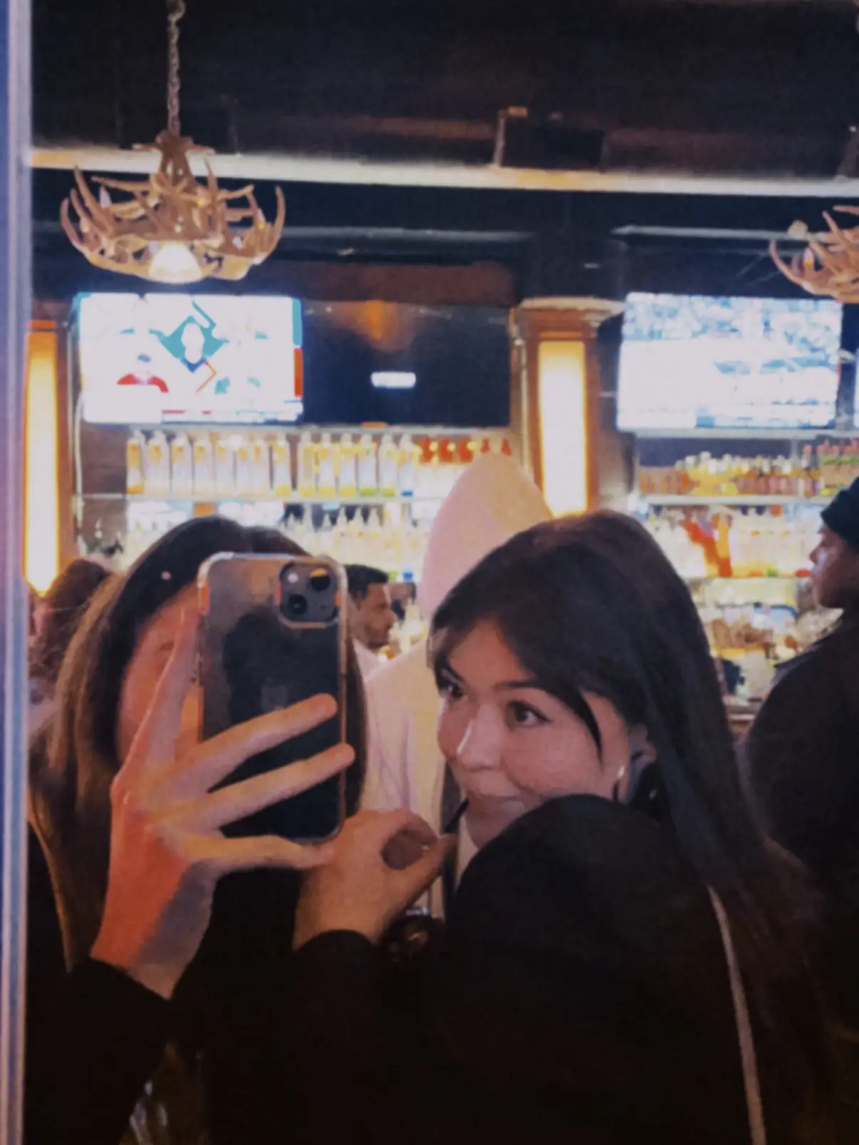  A woman taking a selfie in a bar.