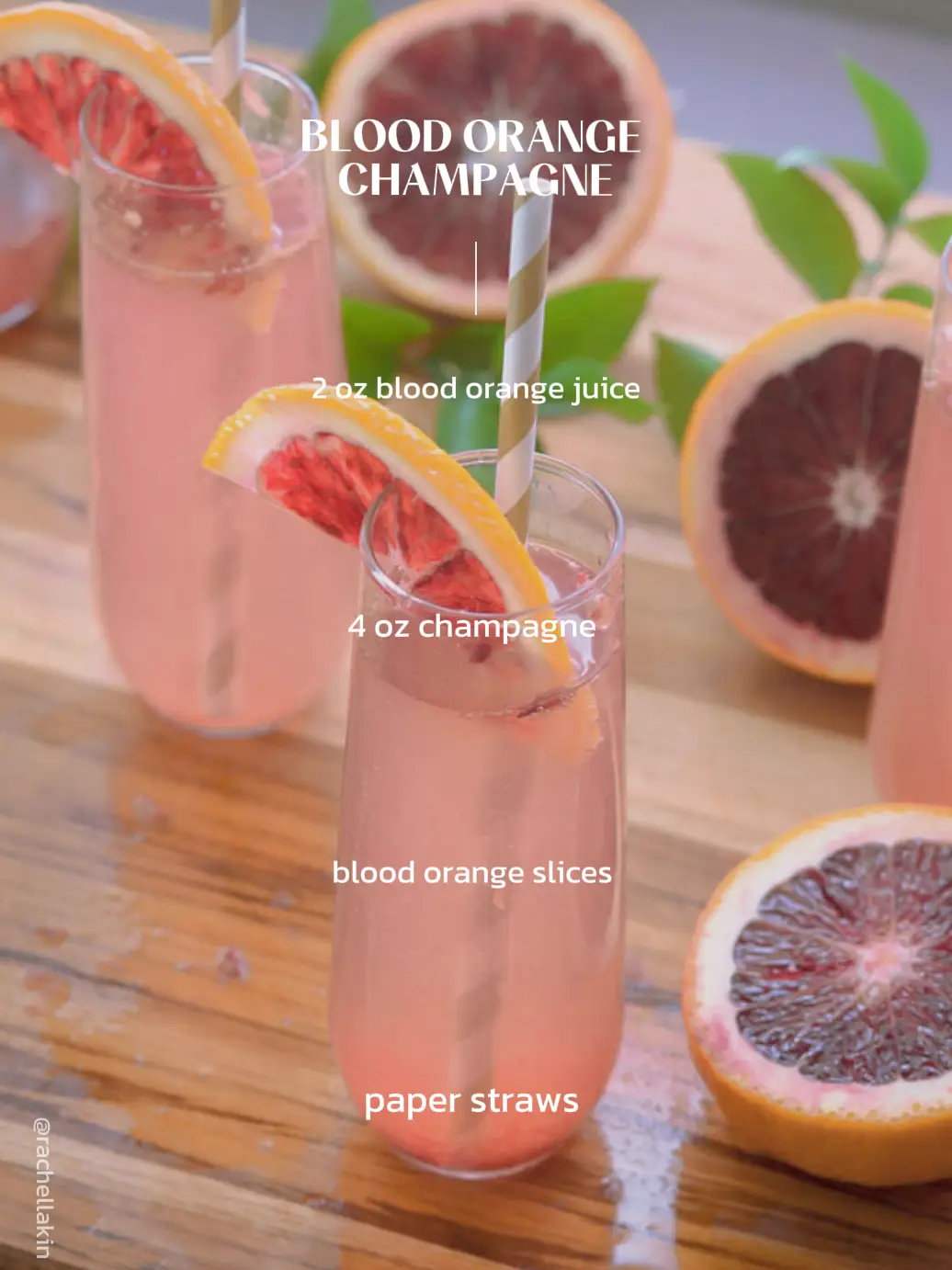  A bottle of champagne and two blood orange slices are displayed.