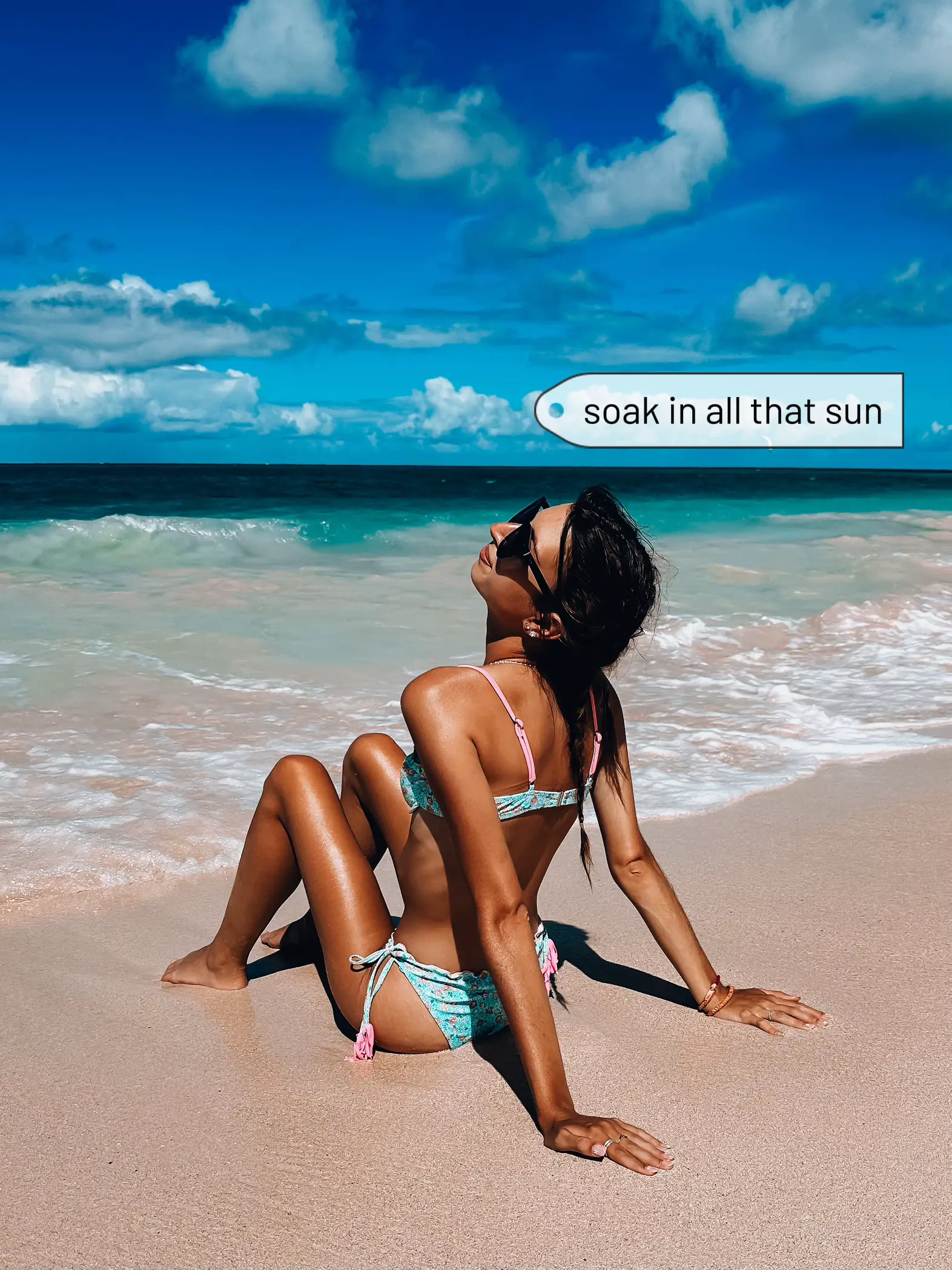 It's a beach bum summer⛱️ Description: a person wears a black bikini set,  blue and white print head scarf and black sunglasses. Th