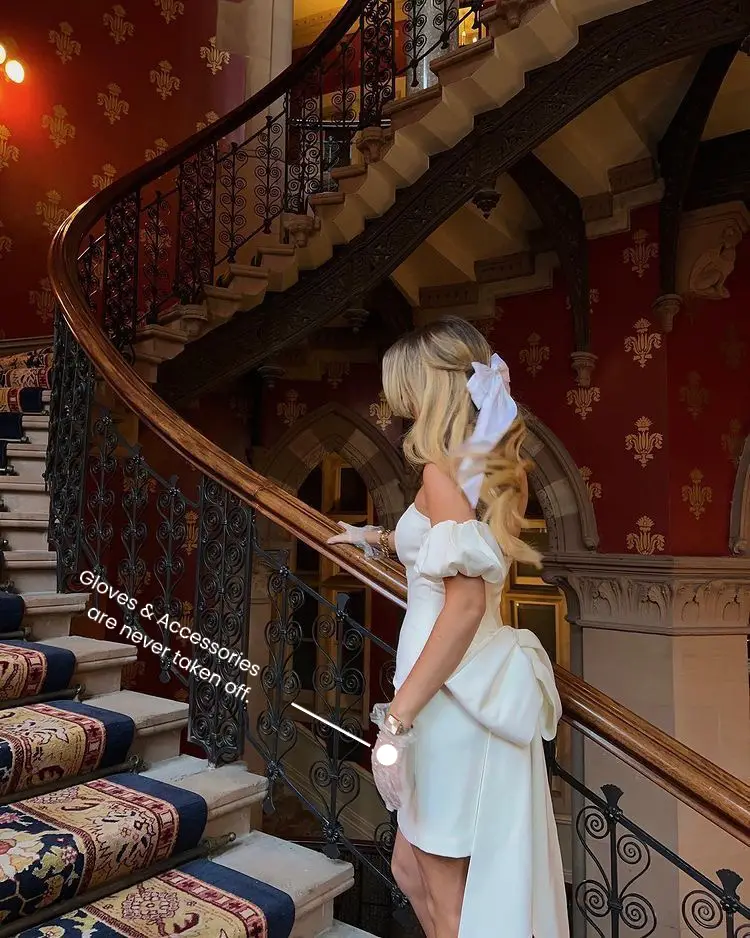  A woman in a white dress is walking down a staircase.