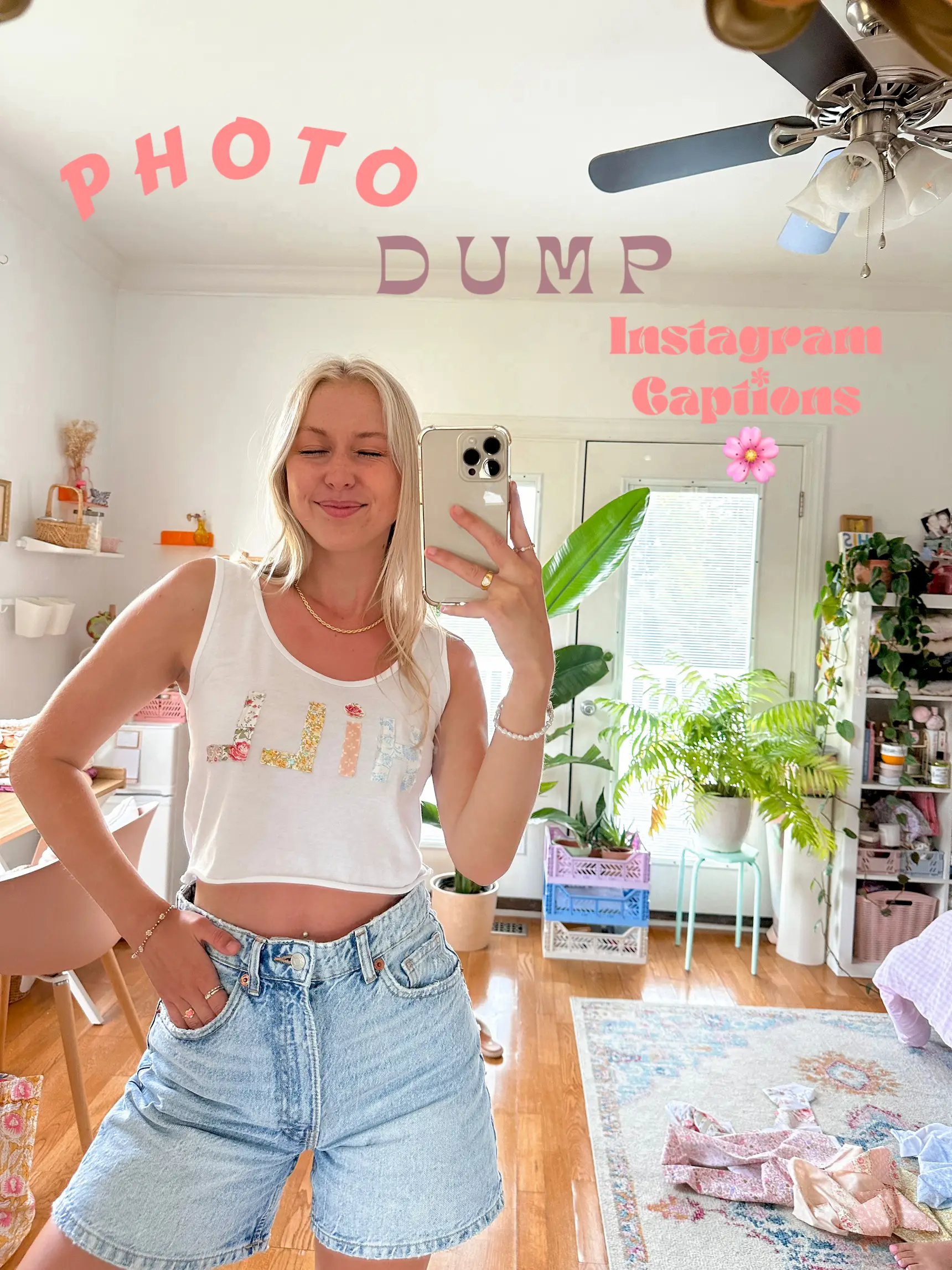 A woman in a blue shirt and white shorts is taking a selfie in a room.