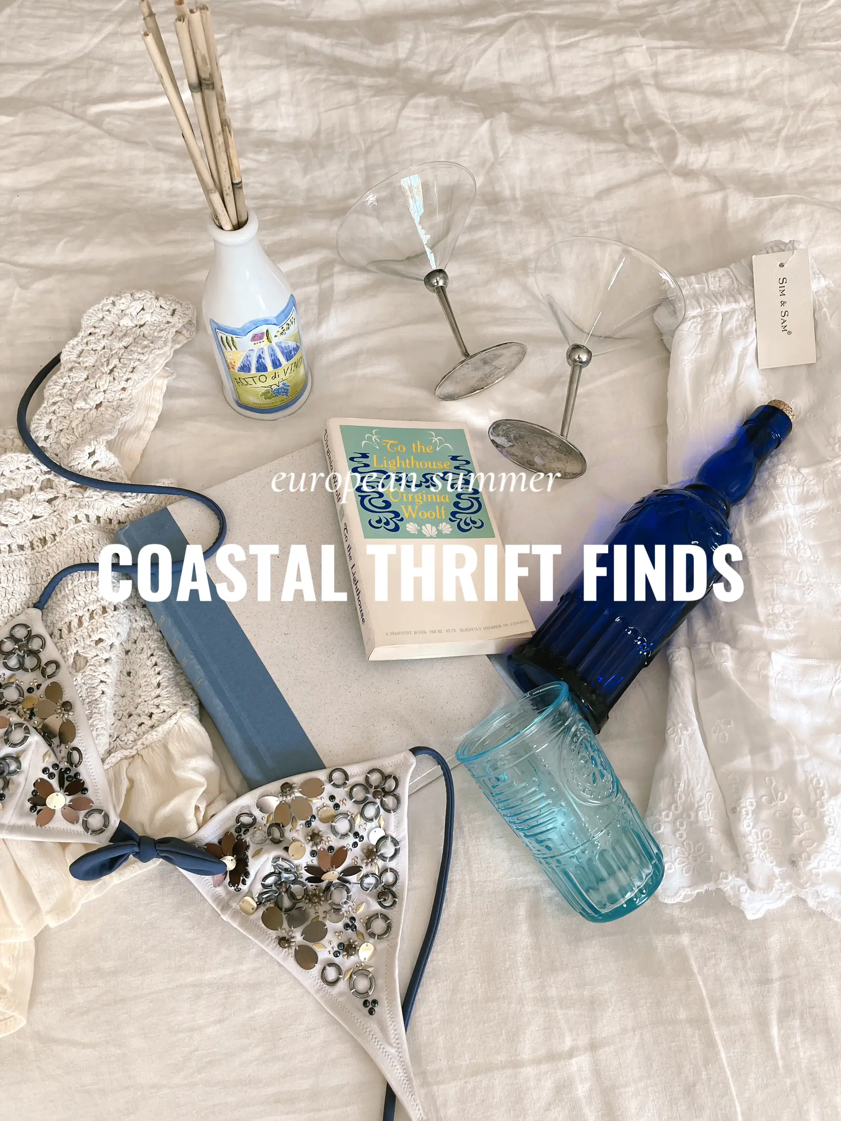  A pile of junk on a beach with a sign that says "Costal Thief Finds".