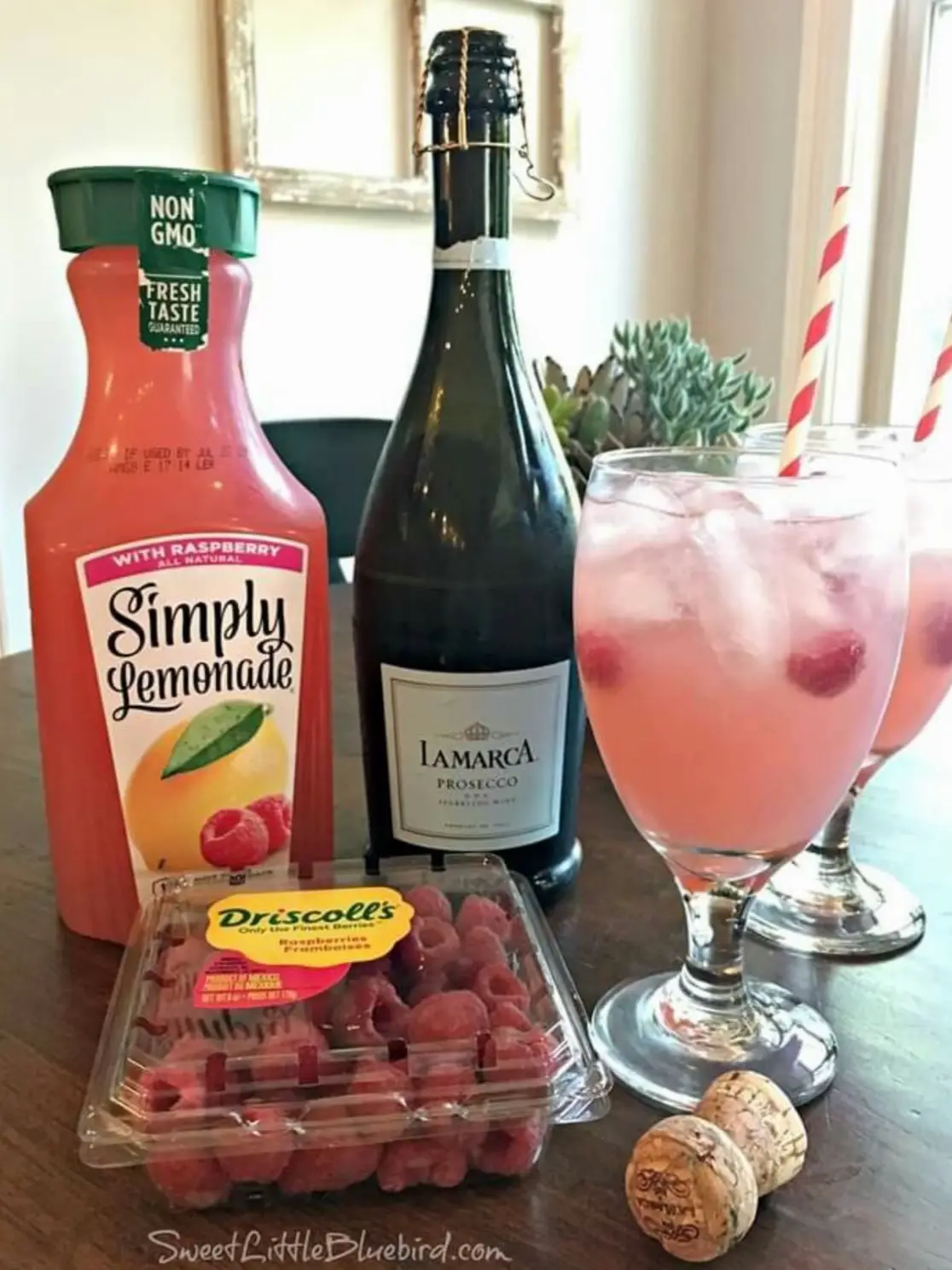  A bottle of Simple Lemonade, a bottle of grapefruit juice, a bottle of lime juice, a bottle of pomegranate juice, a bottle of arugula, and a glass of