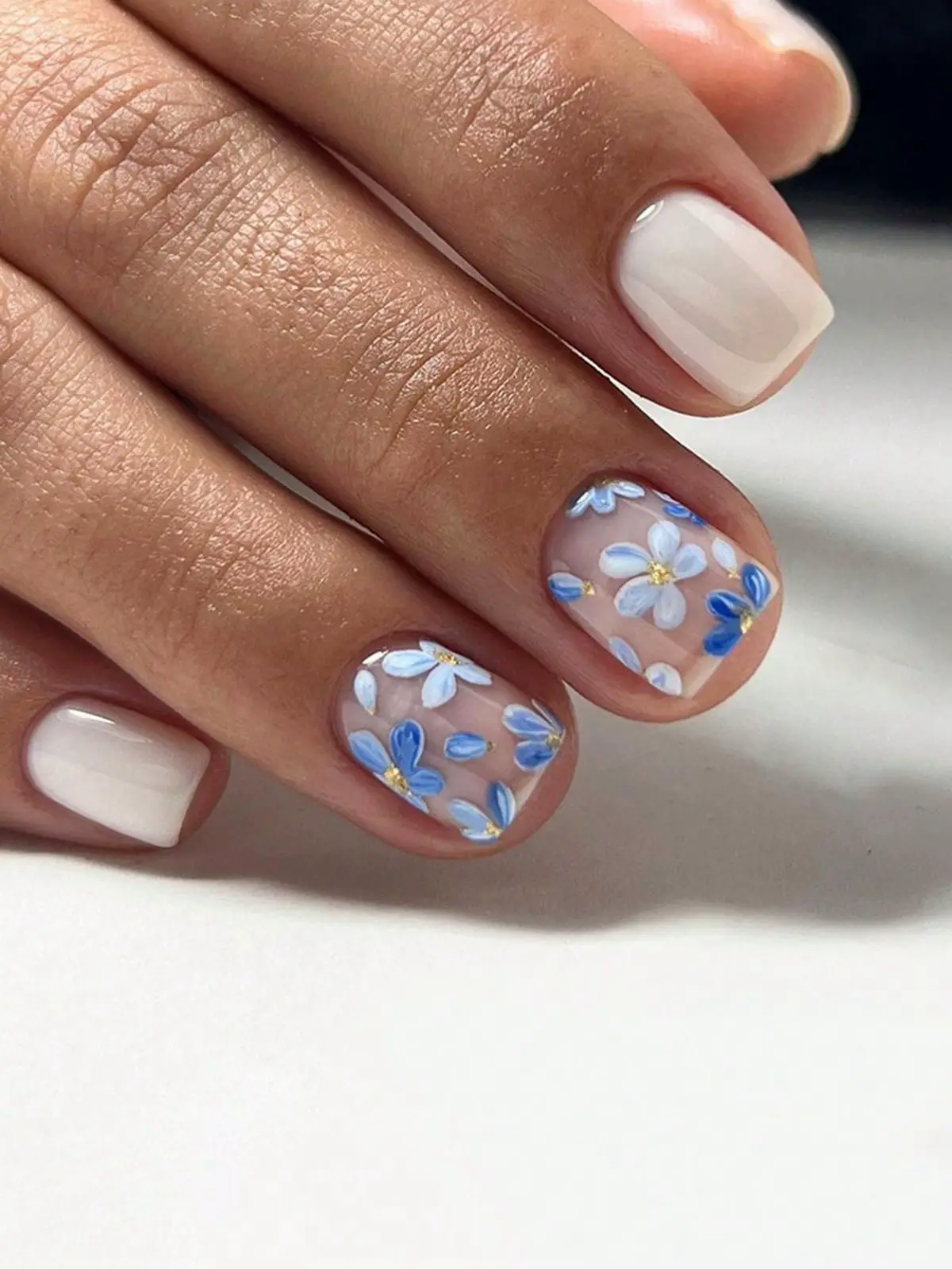  A hand with a flower design on the nail.