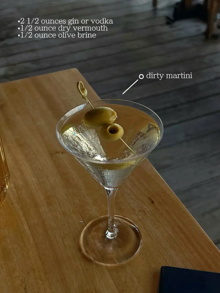  A dirty martini with a olive brine and a lemon wedge.
