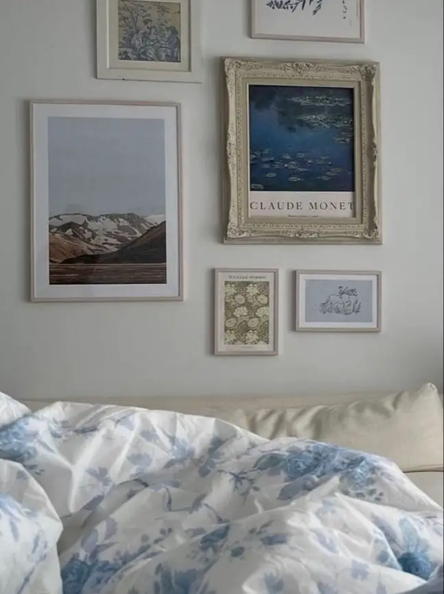  A bed with a white comforter and a picture of a painting of a beach.