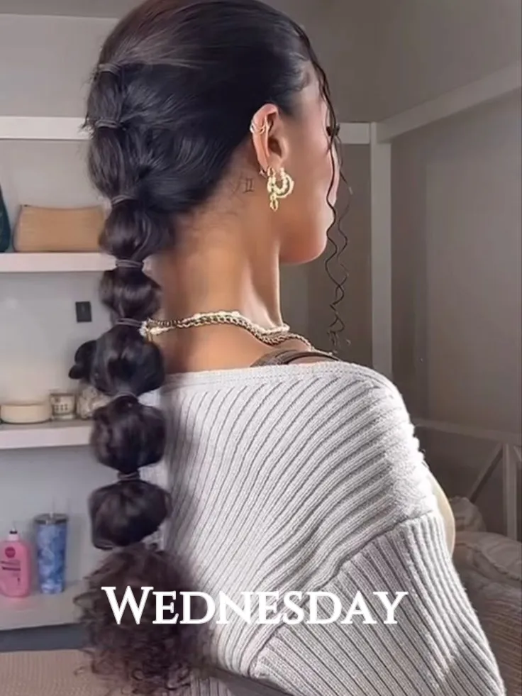  A woman with a braid in her hair and a white sweater.