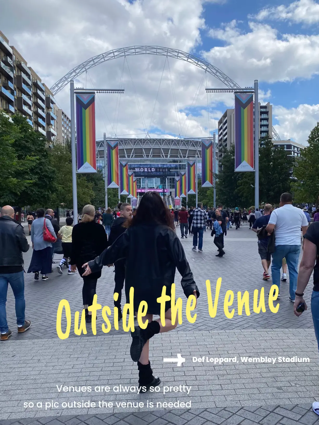  A woman is walking down a sidewalk with a sign that says "Outside the Venue"