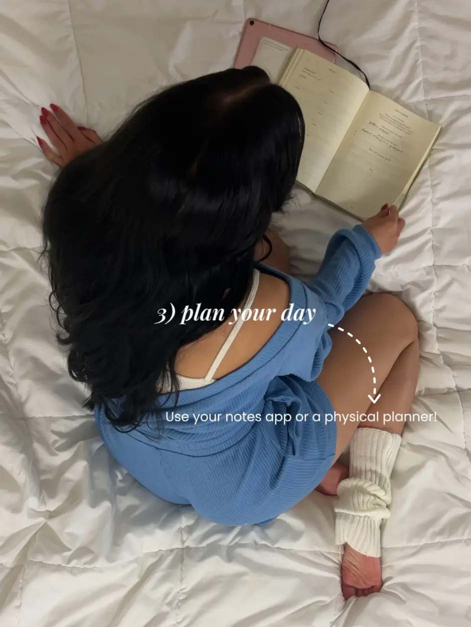  A woman is laying on a bed with a book.