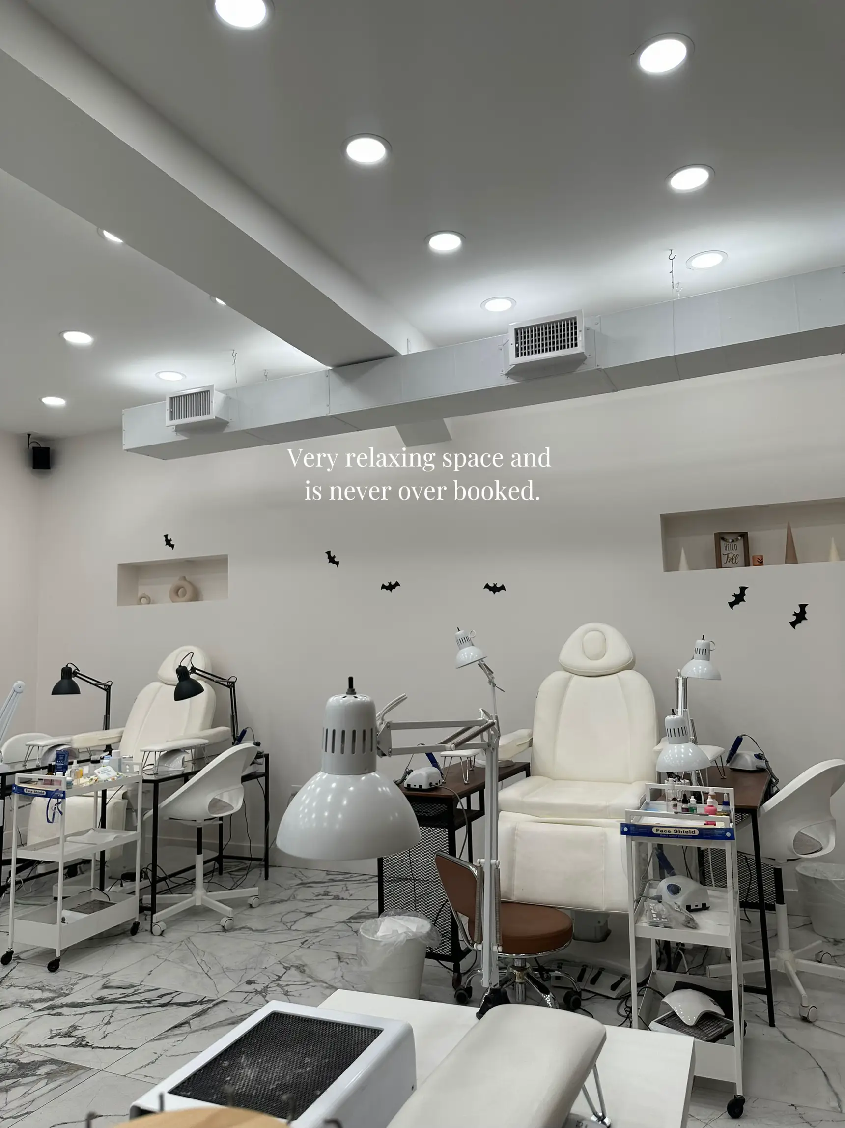  A salon with a white wall and a sign that says "Very relaxing space and is never over booked".