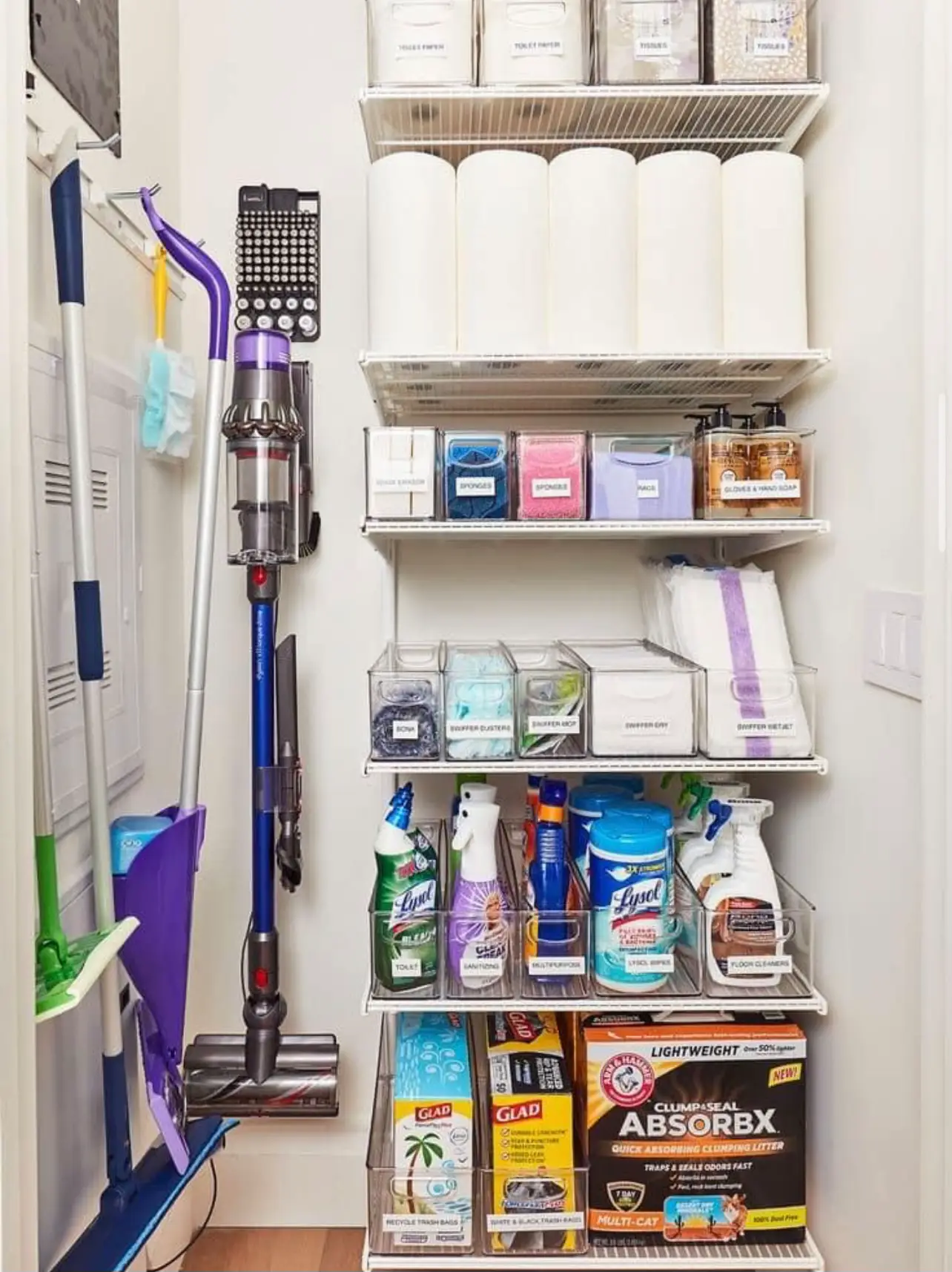  A refrigerator with a vacuum and cleaning supplies inside.