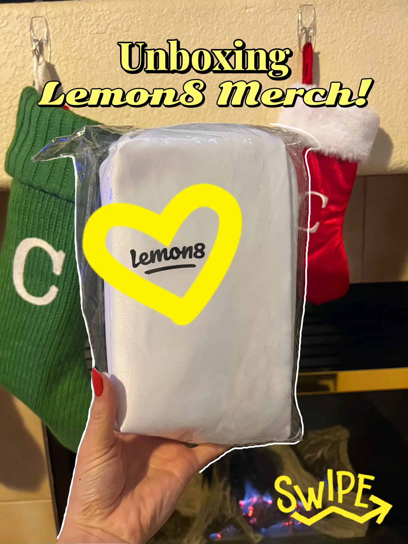 A person is holding a white gift bag with a green bow. The bag is labeled with the words "Lemonade" and "Swipe".