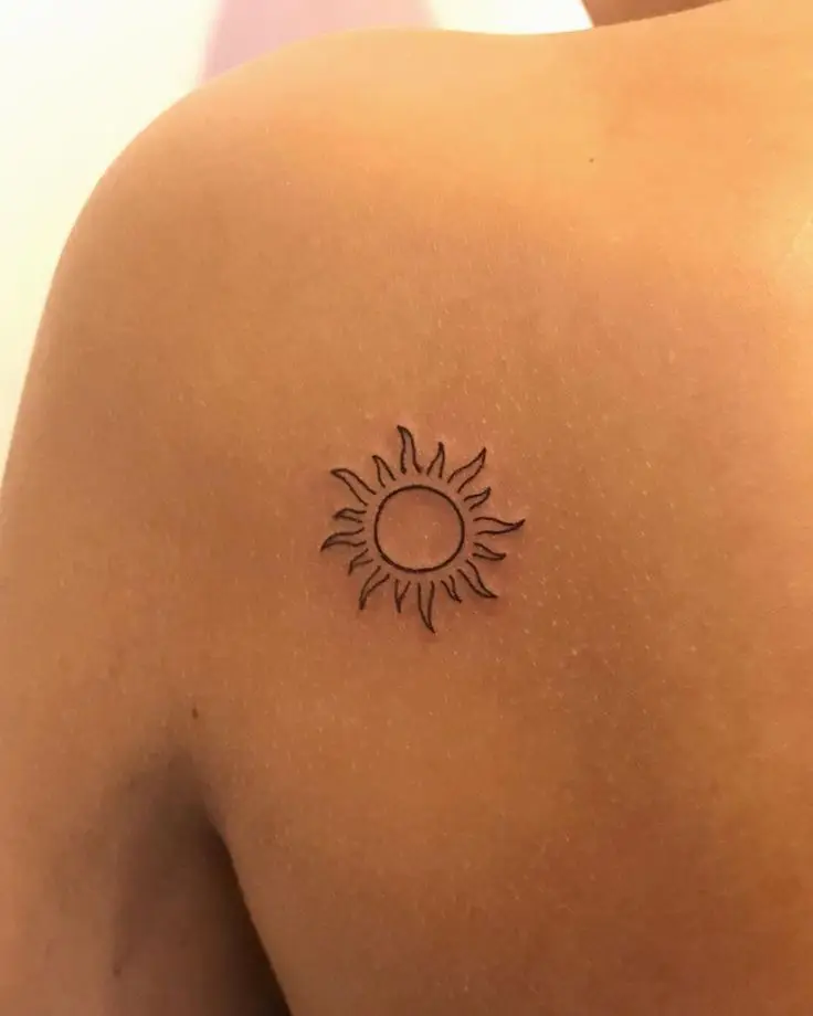  A sun tattoo on a person's arm.