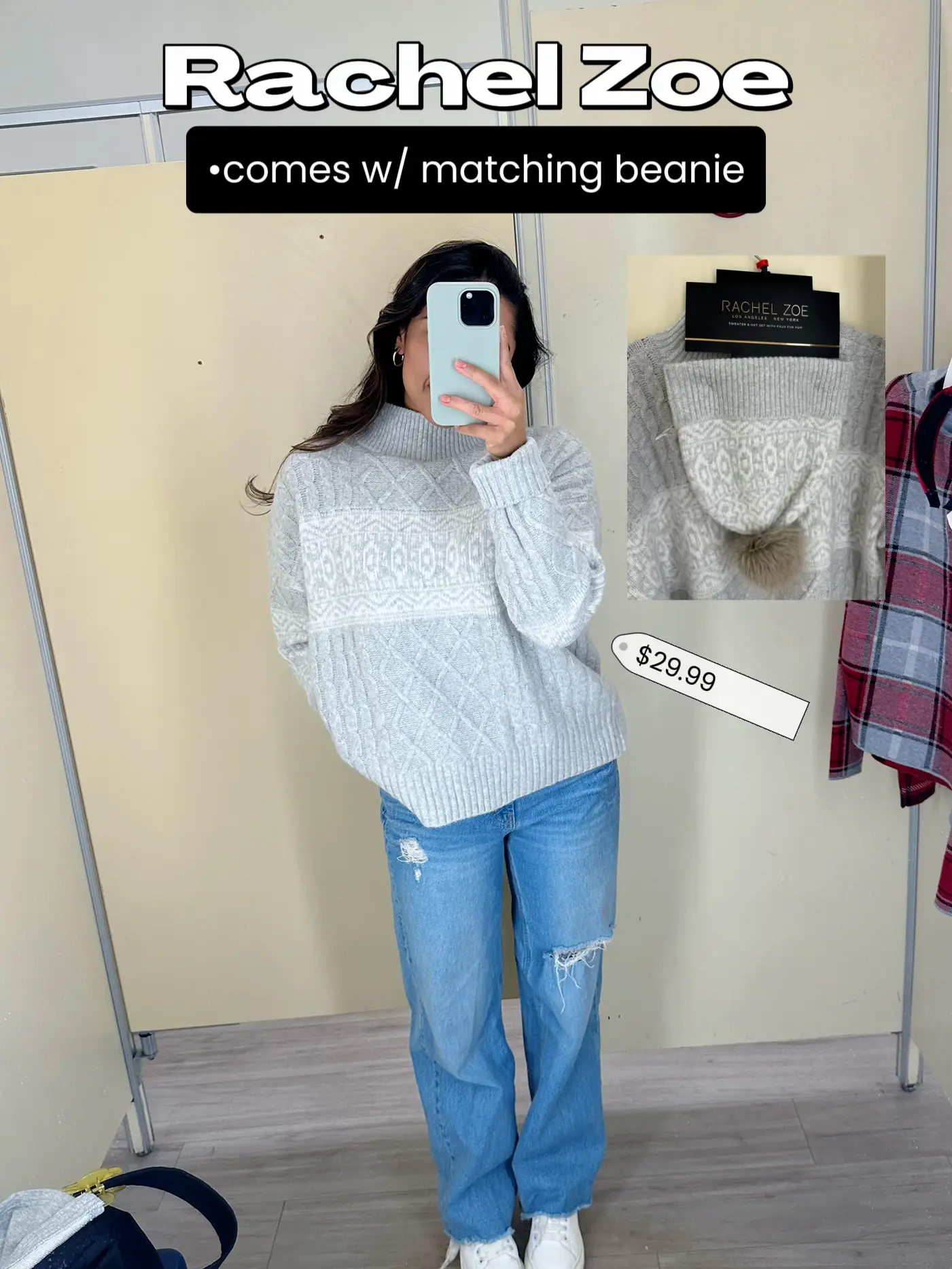  A woman in a white sweater and jeans is taking a selfie in a store.