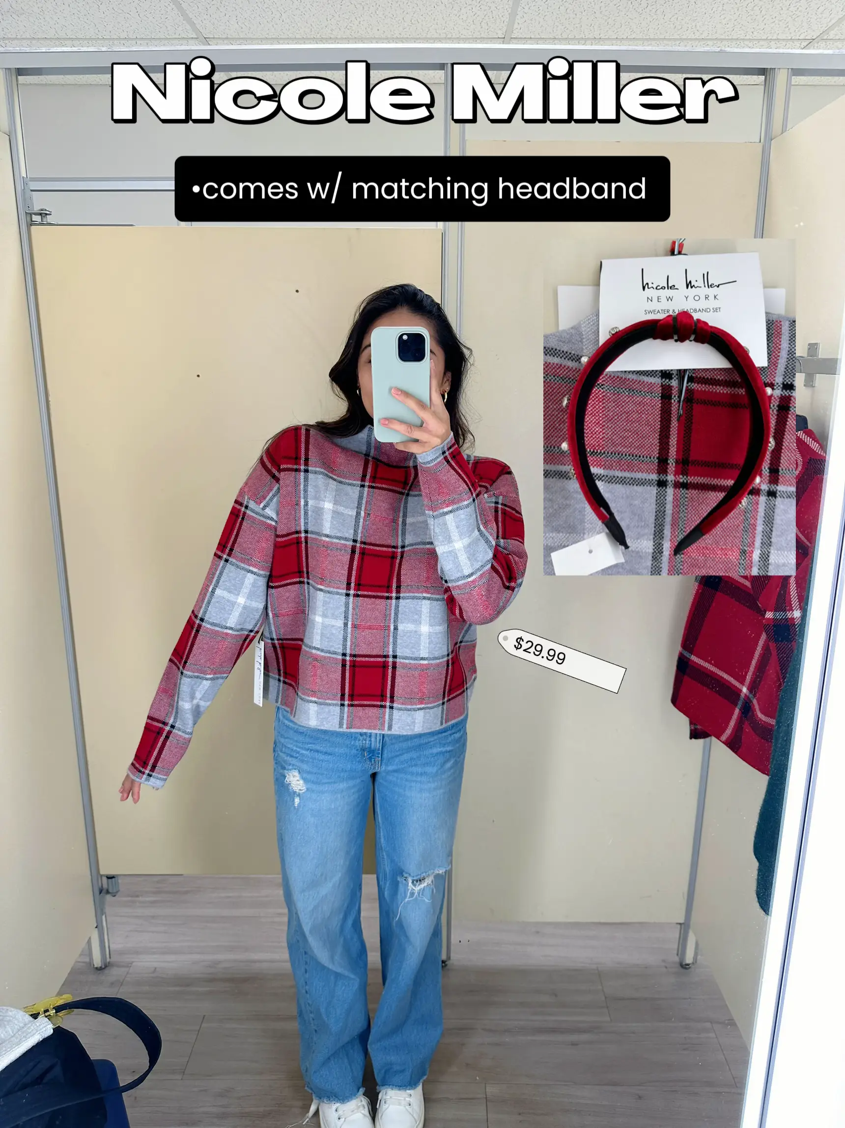  A woman taking a selfie in a store with a plaid sweater and a headband.