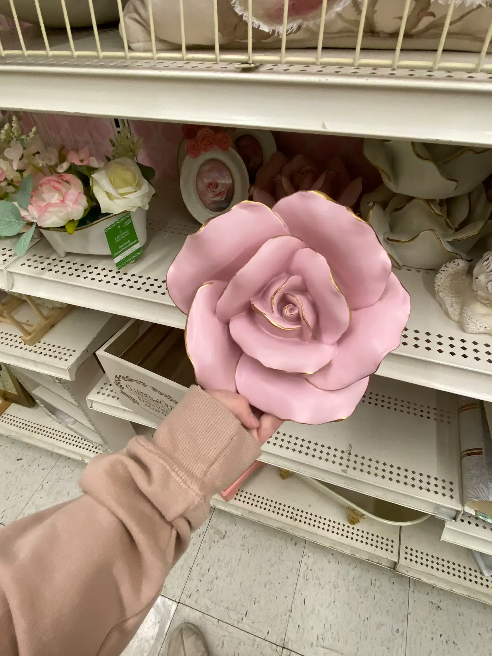  A hand holding a pink rose.