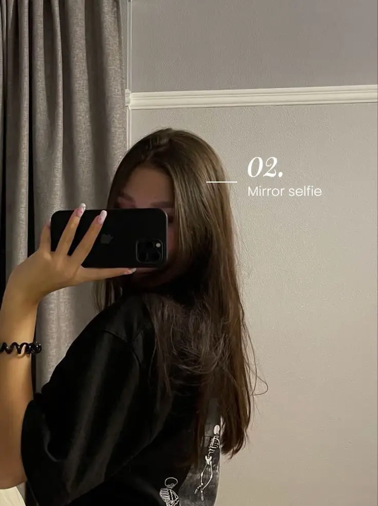  A woman is taking a selfie in front of a mirror.
