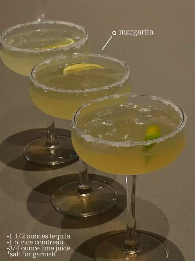  Four glass of margarita with a lime wedge in each.