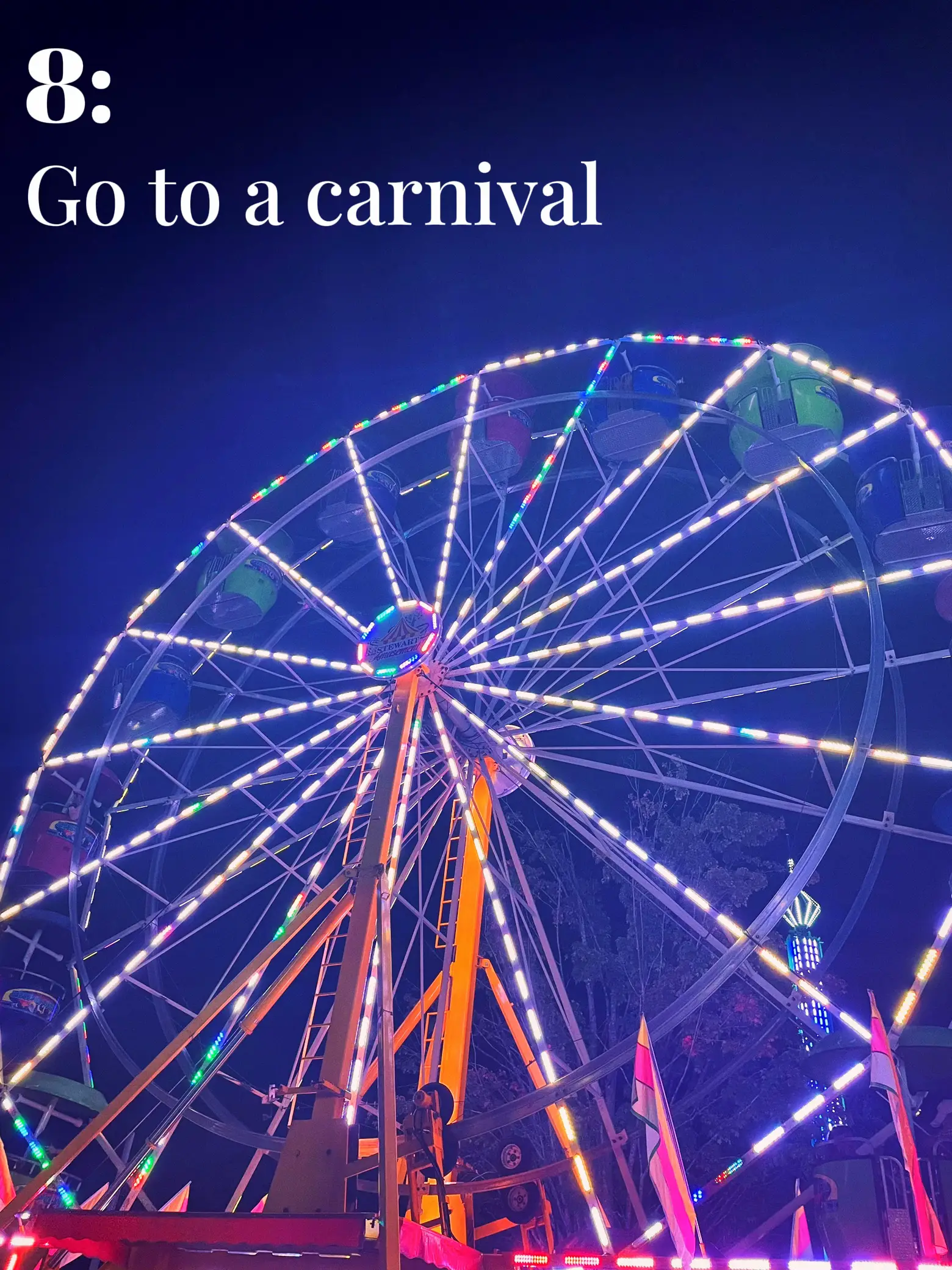  A large ferris wheel with lights on and a sign that says "Go to a carnival".