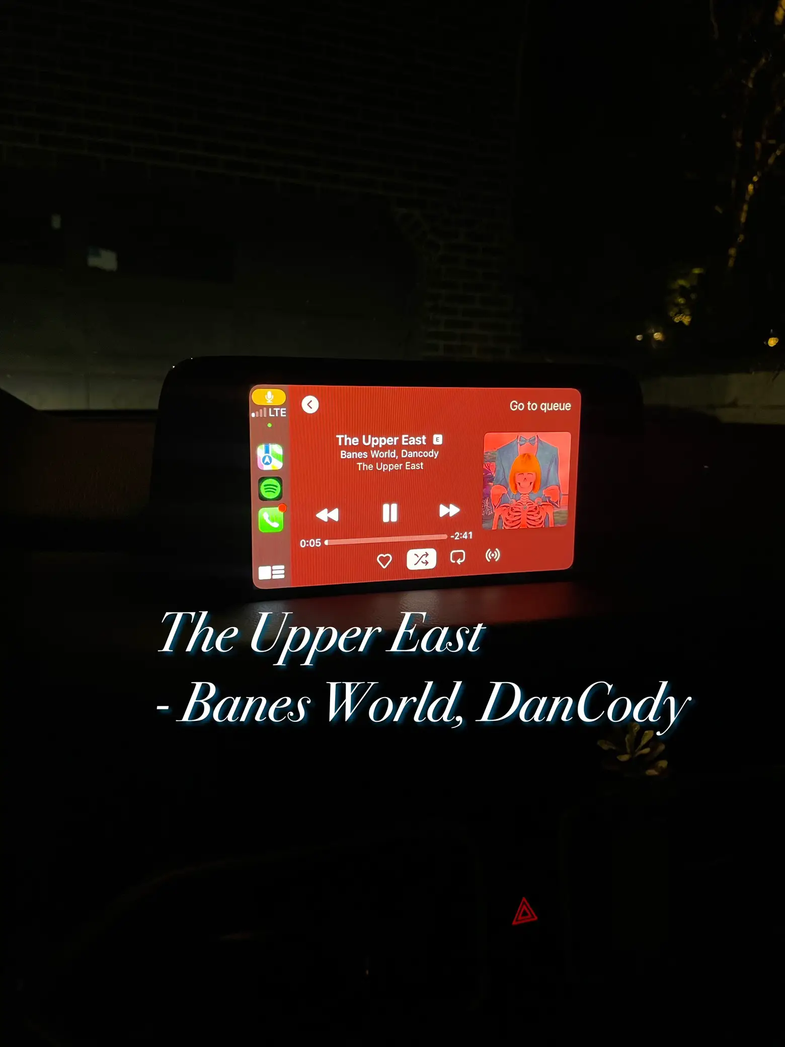  A car's dashboard with a playlist of music on it.