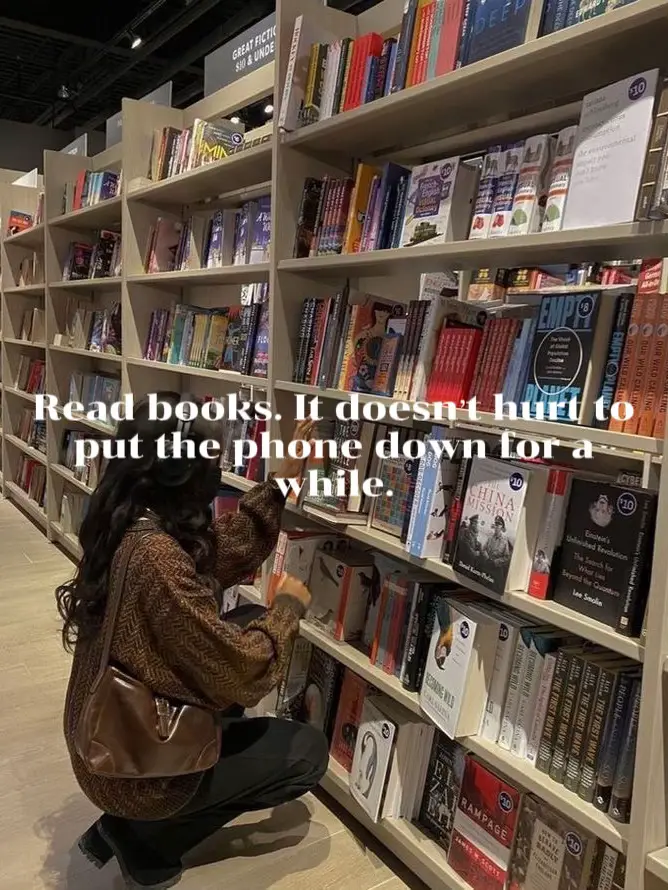  A woman is sitting in a bookstore, reading a book.