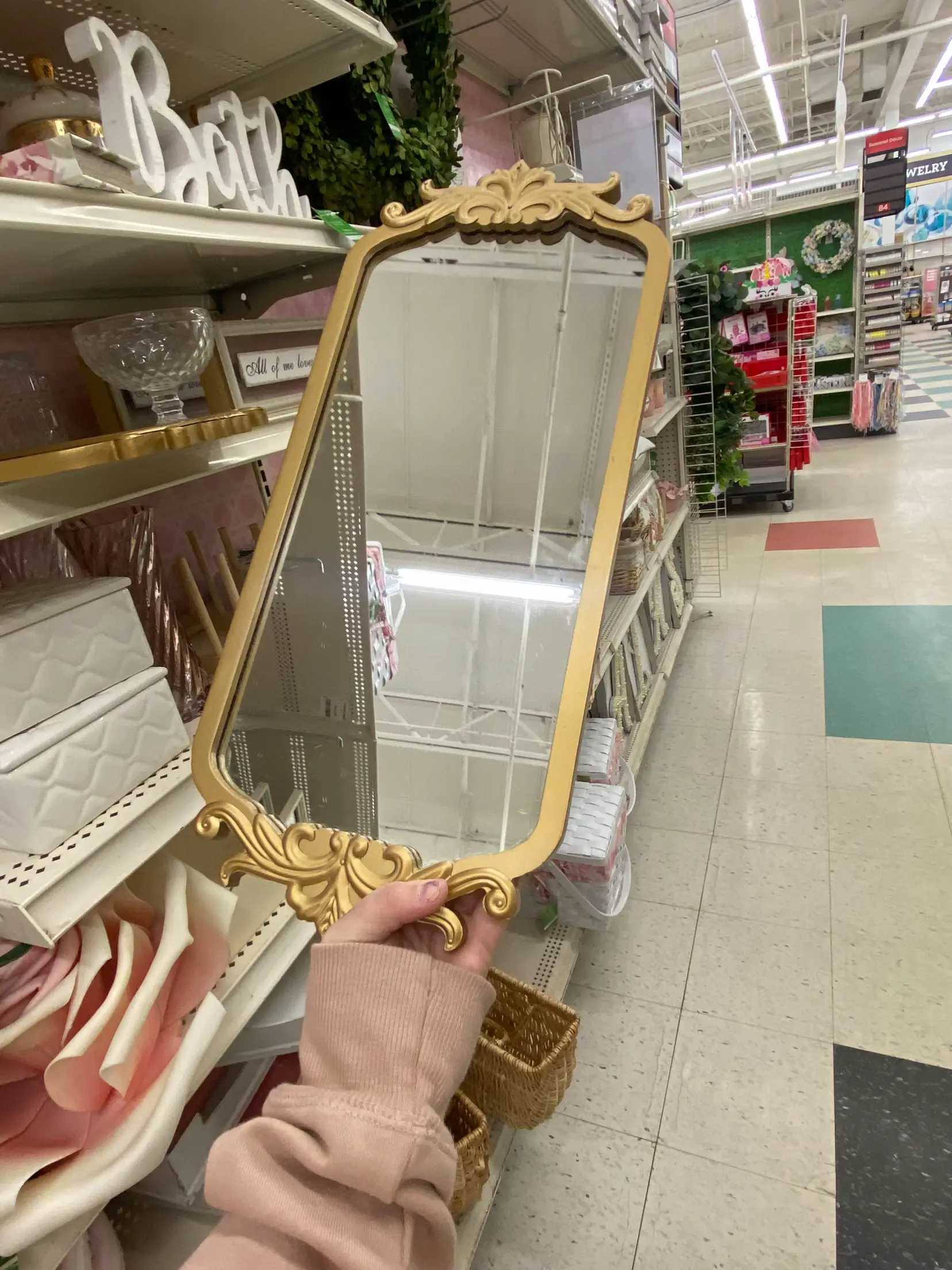  A mirror with a gold frame is being held by a person.