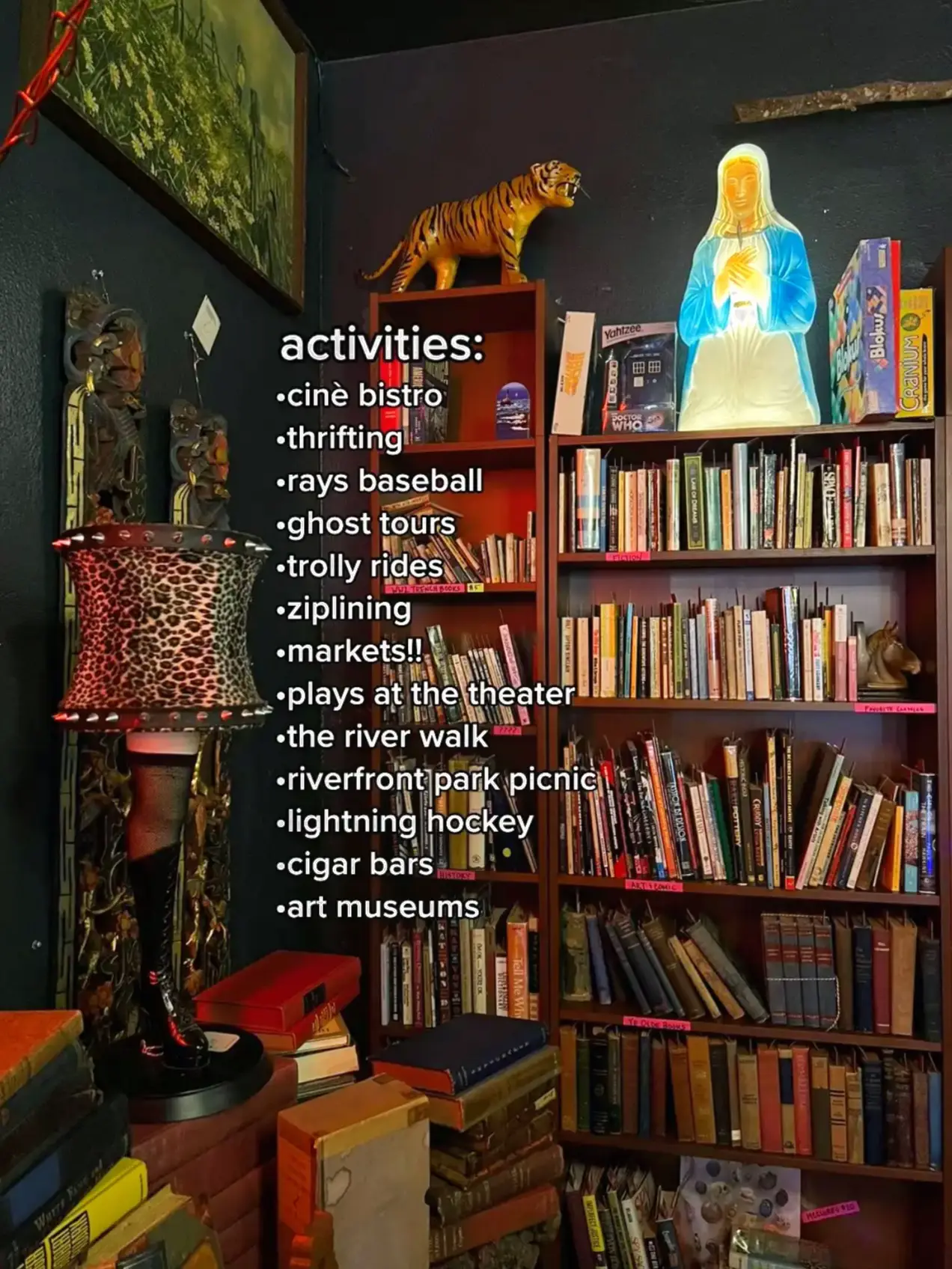  A bookshelf with a variety of books and a statue.