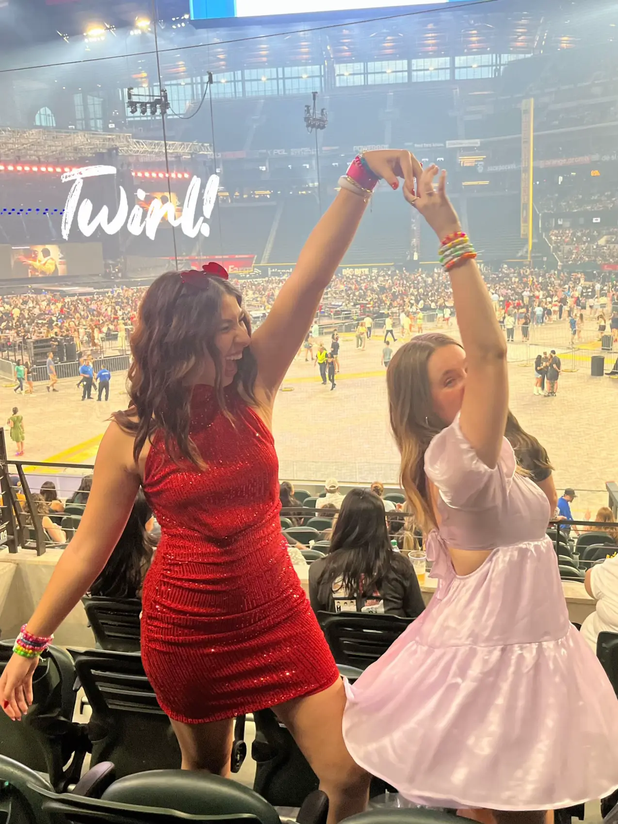  Two women in red dresses are standing in a stadium.