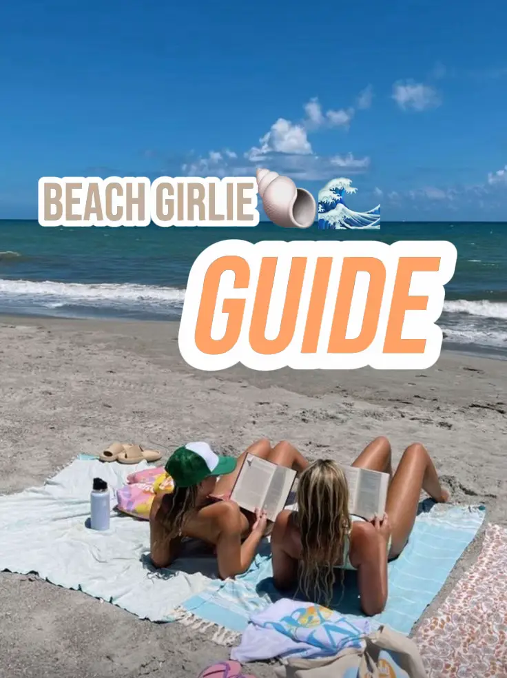  Two women are laying on a towel on the beach, reading books.